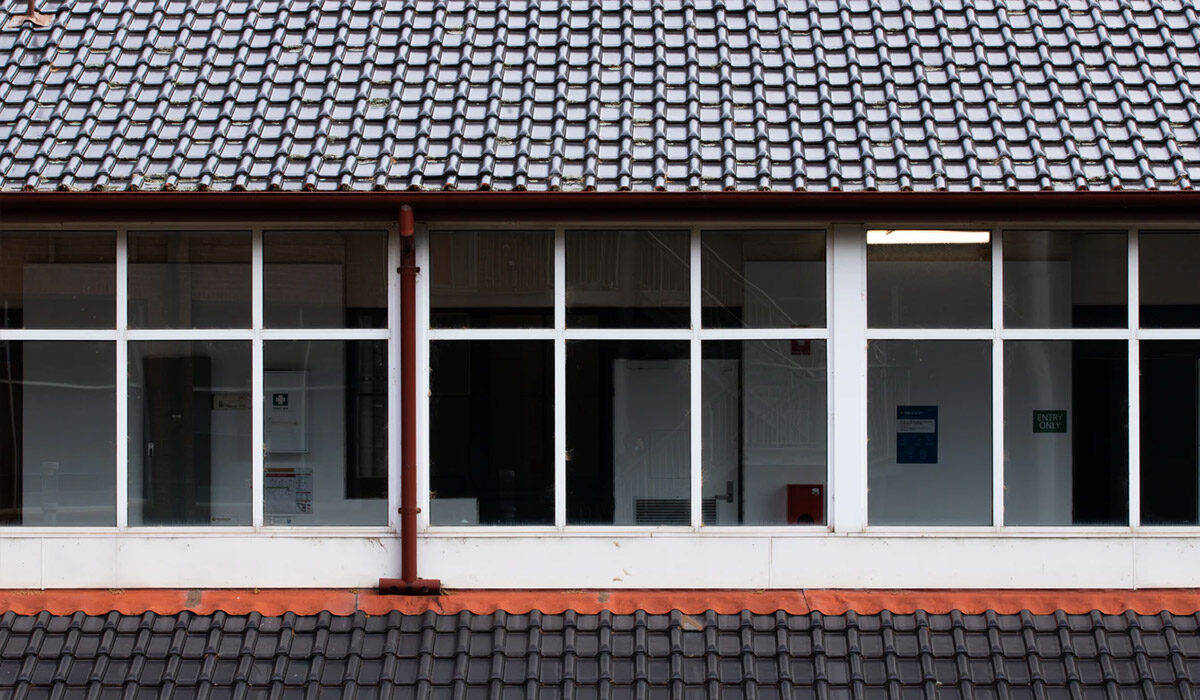 Building exterior with large windows under a tiled roof