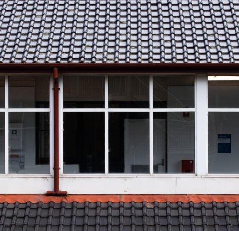 Building exterior with large windows under a tiled roof