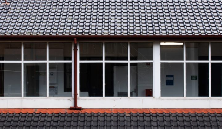 Building exterior with large windows under a tiled roof